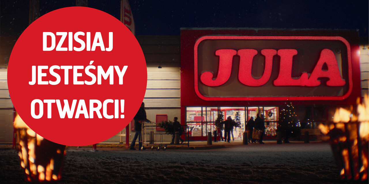 Wieczorna scena przed sklepem Jula z dużym, podświetlonym czerwonym logo nad wejściem. Na pierwszym planie widoczne są płonące pochodnie, a w tle grupa os&oacute;b wchodzi do sklepu. Po lewej stronie znajduje się duże czerwone koło z białym napisem: &lsquo;DZIŚ JESTEŚMY OTWARCI!&rsquo;.