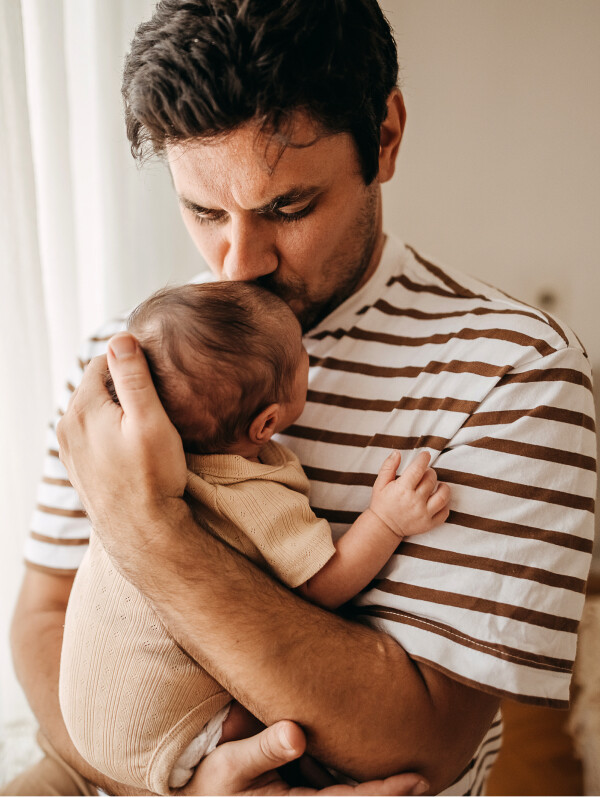 Image of father holding his newborn.